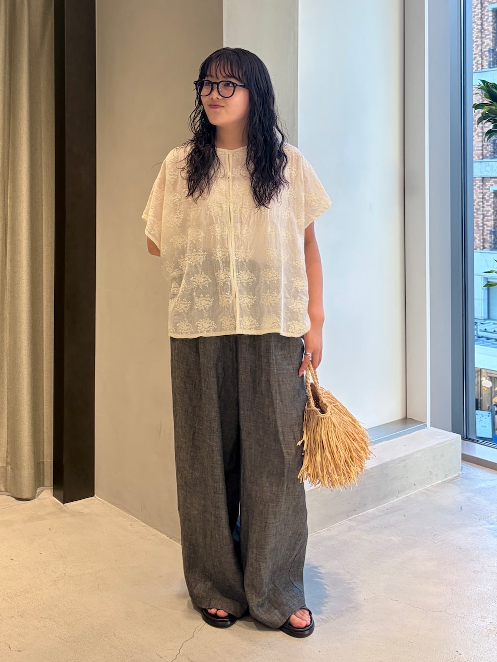 ホワイト系のシャツ/ブラウス、ブラック系のその他パンツ、ベージュ系のハンドバッグを着用したレディースの夏コーディネートの3枚目の写真