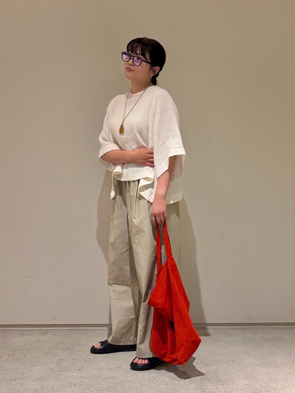 ベージュ系のその他パンツ、ブラック系のサンダル、ホワイト系のシャツ/ブラウスを着用したレディースの夏コーディネートの3枚目の写真