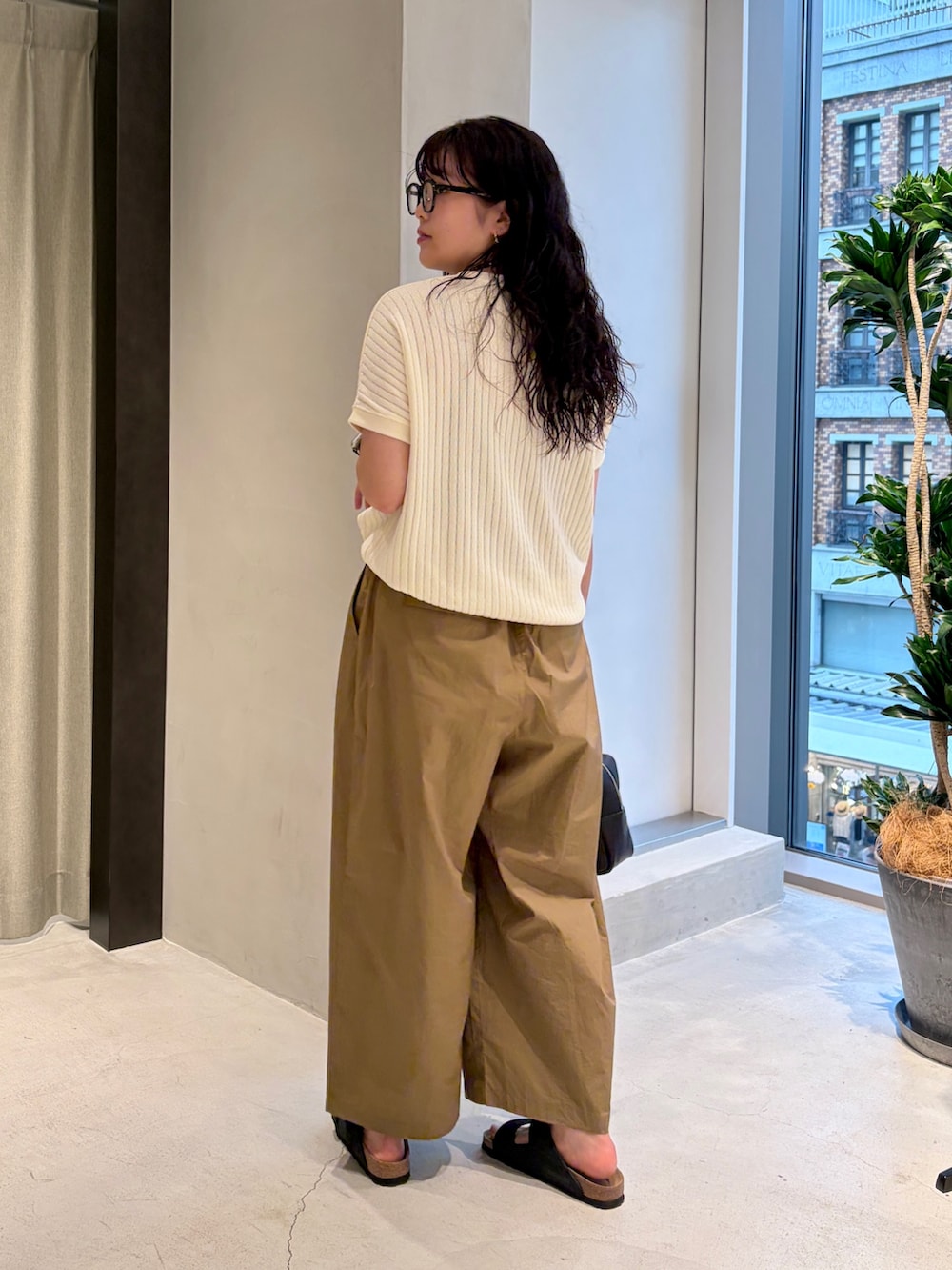 ホワイト系のTシャツ/カットソー、ベージュ系のその他パンツ、ブラック系のハンドバッグを着用したレディースの夏コーディネートの4枚目の写真