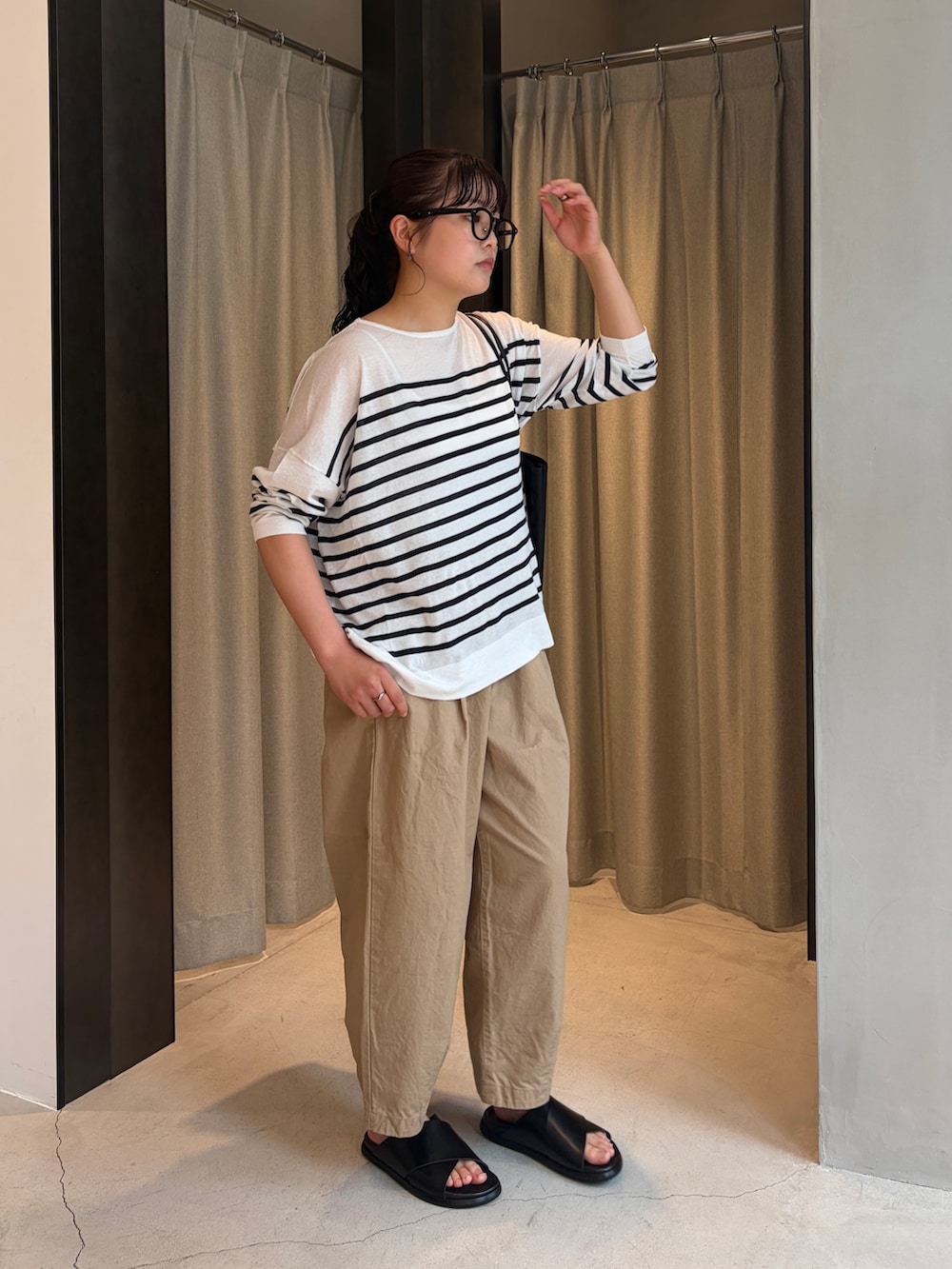 ベージュ系のその他パンツ、ブラック系のサンダル、ブラック系のトートバッグを着用したレディースの夏コーディネートの5枚目の写真