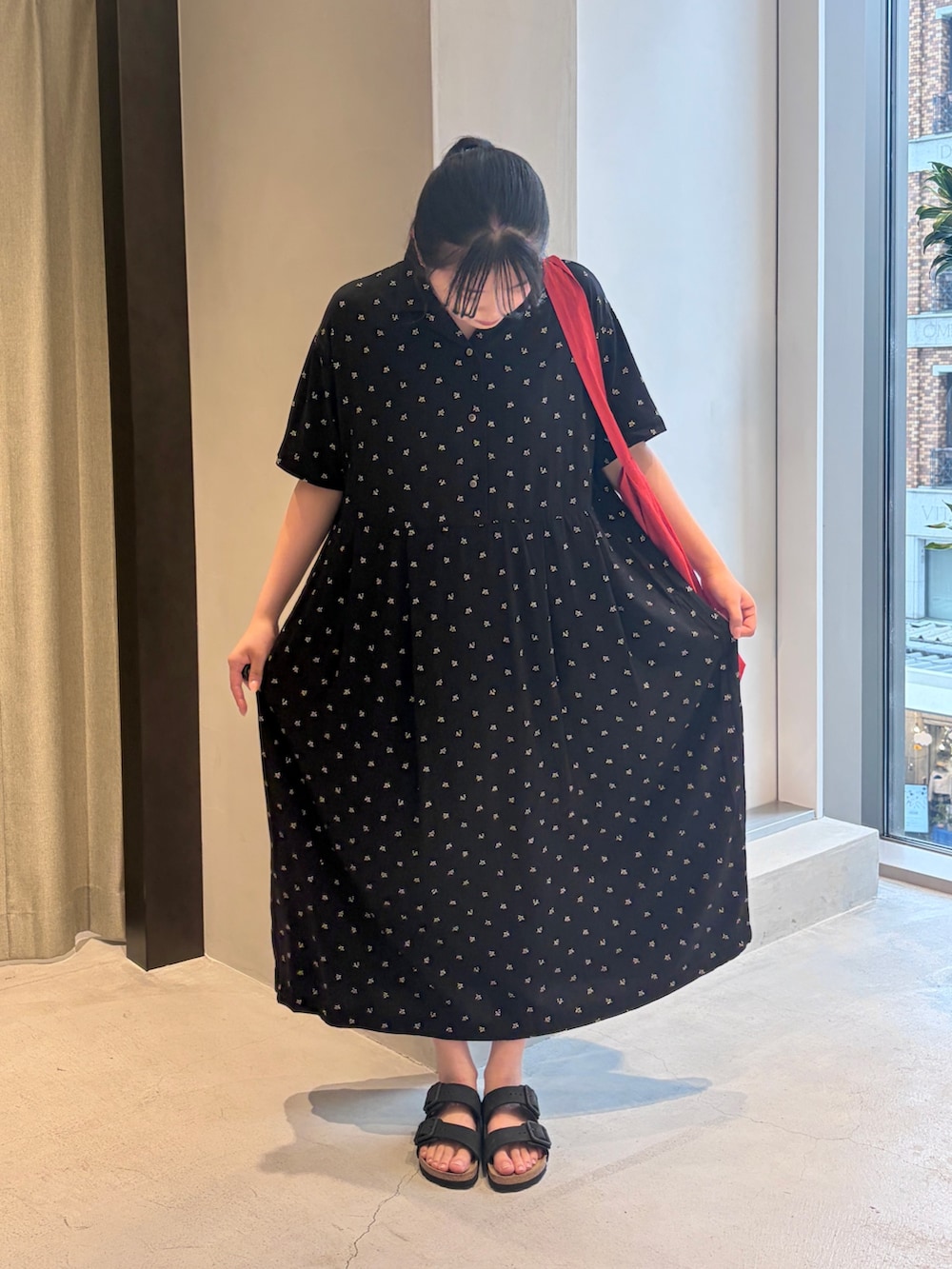 レッド系のショルダーバッグ、ブラック系のワンピース、ブラック系のサンダルを着用したレディースの夏コーディネートの2枚目の写真