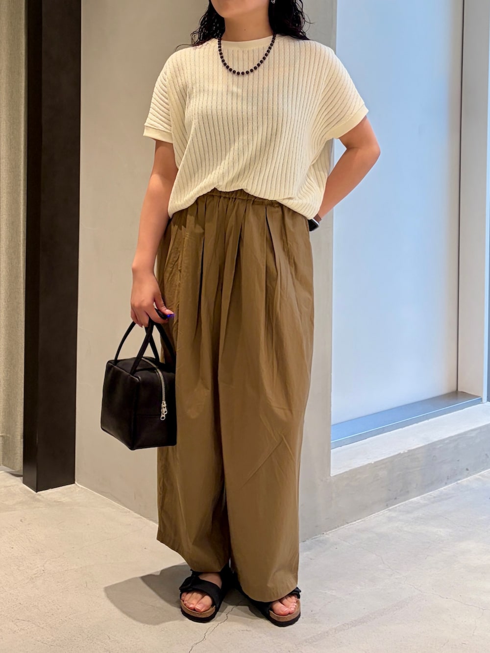 ホワイト系のTシャツ/カットソー、ベージュ系のその他パンツ、ブラック系のハンドバッグを着用したレディースの夏コーディネートの5枚目の写真