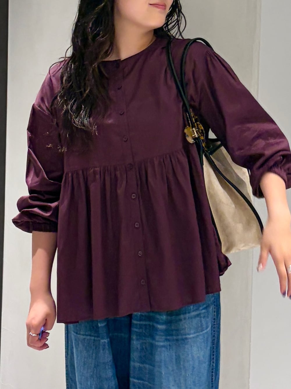 ベージュ系のスニーカー、ブルー系のデニムパンツ、レッド系のシャツ/ブラウスを着用したレディースの秋コーディネートの6枚目の写真