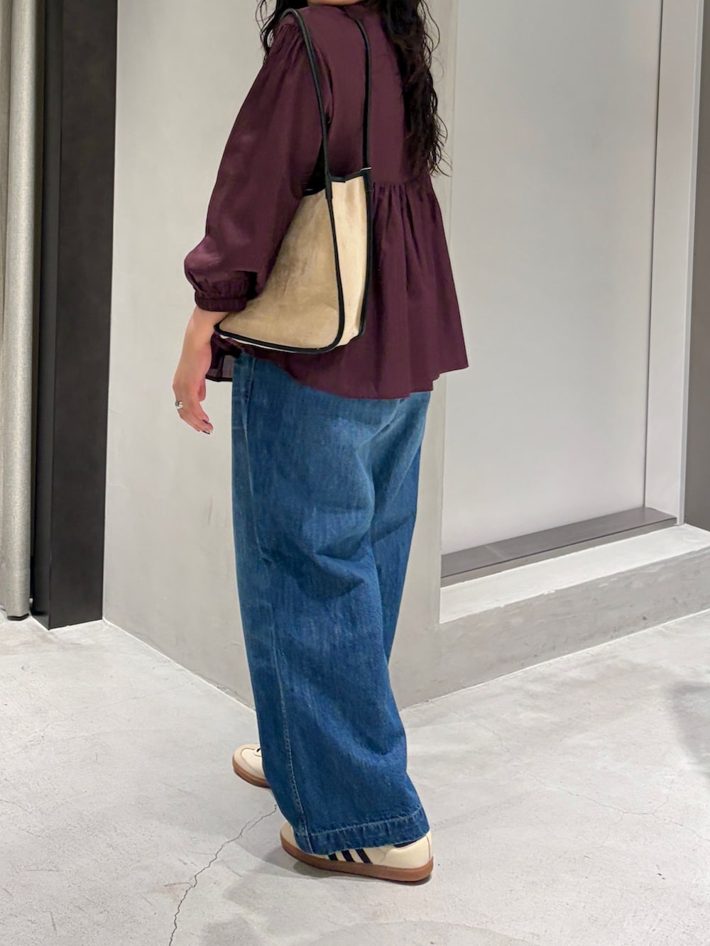 ベージュ系のスニーカー、ブルー系のデニムパンツ、レッド系のシャツ/ブラウスを着用したレディースの秋コーディネートの4枚目の写真