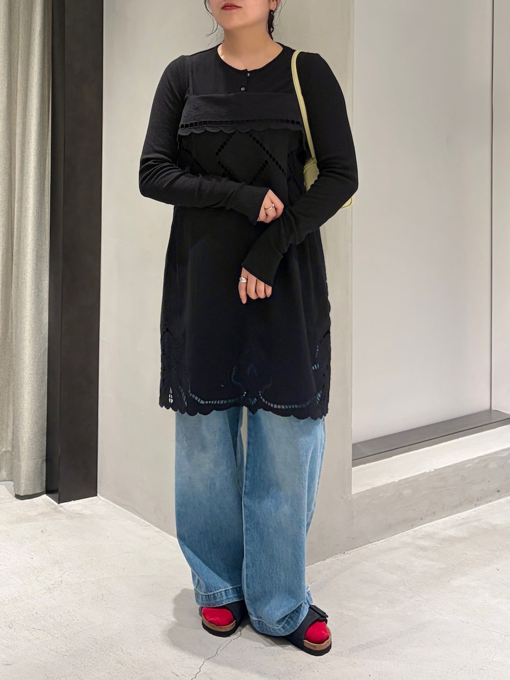ブルー系のデニムパンツ、ブラック系のカーディガン/ボレロ、イエロー系のハンドバッグを着用したレディースの夏コーディネートの6枚目の写真