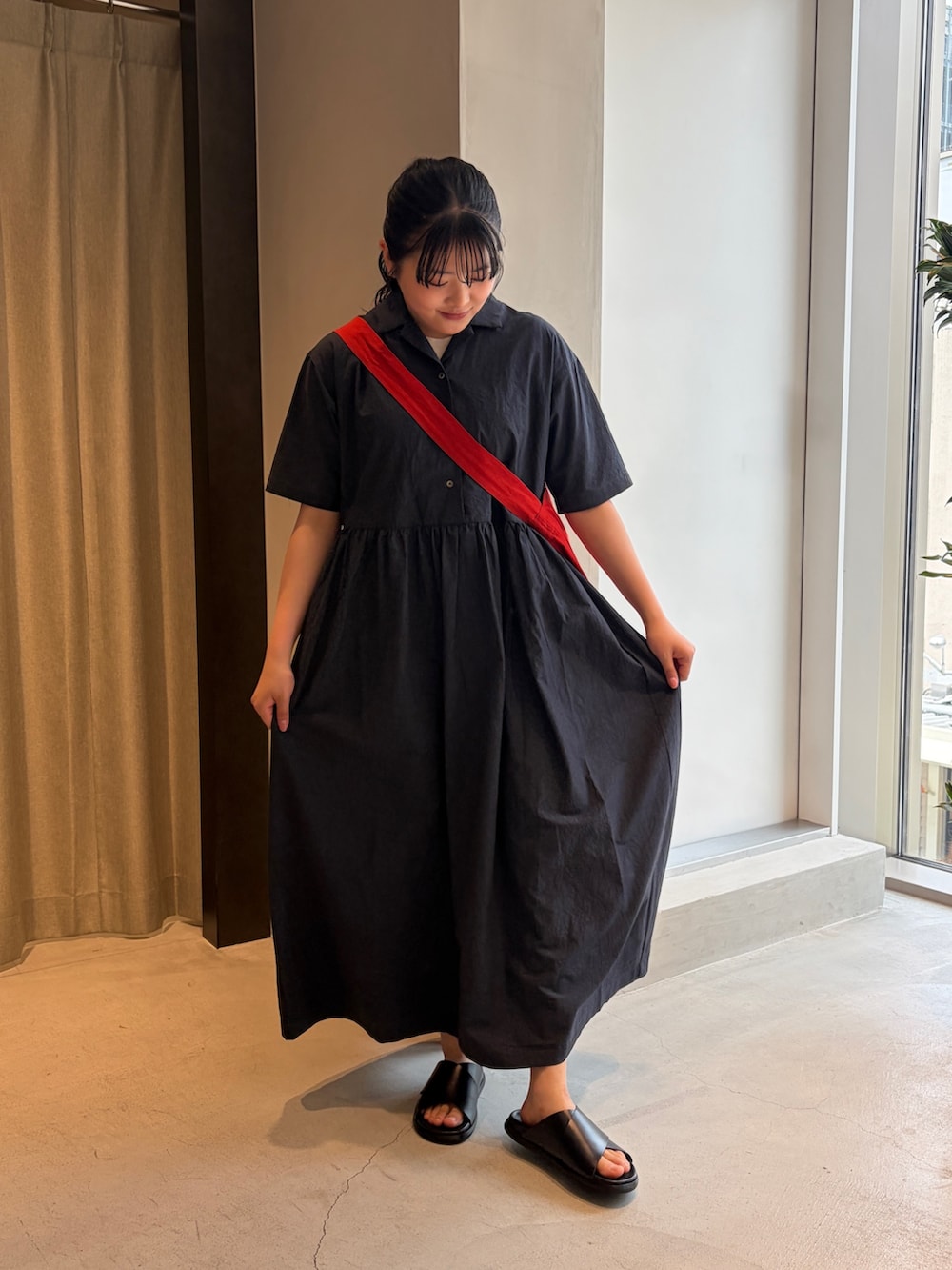 レッド系のショルダーバッグ、ブルー系のワンピース、ブラック系のサンダルを着用したレディースの夏コーディネートの2枚目の写真