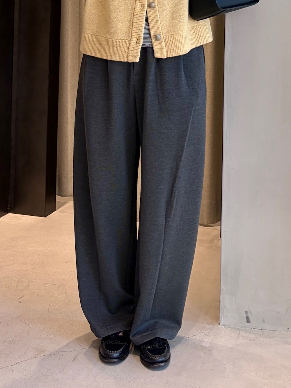 グレー系のその他パンツ、イエロー系のカーディガン/ボレロ、ブラック系のハンドバッグを着用したレディースの秋コーディネートの4枚目の写真