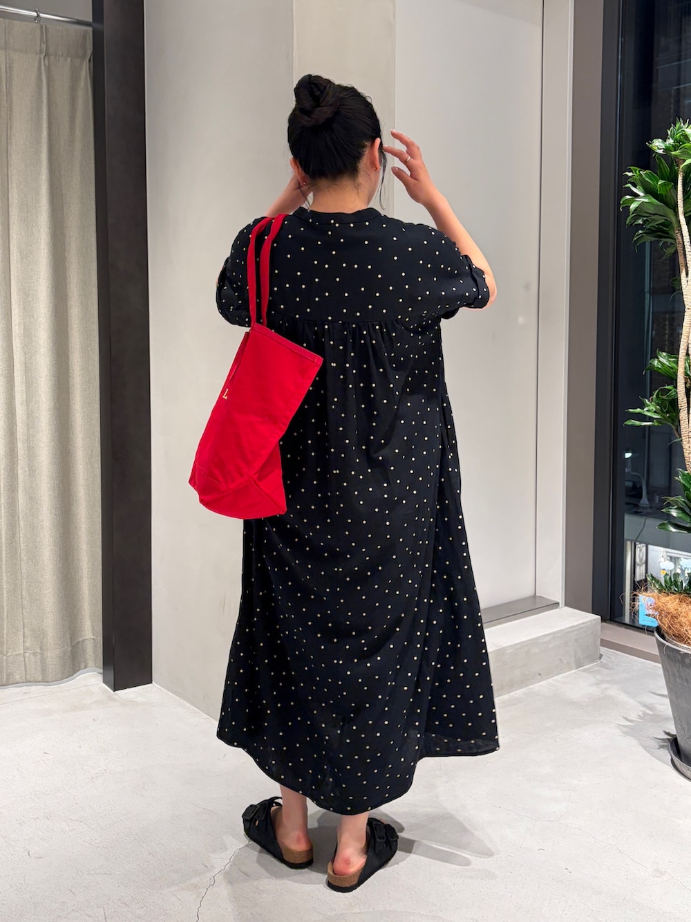 ブラック系のワンピース、レッド系のトートバッグ、ブラック系のサンダルを着用したレディースの夏コーディネートの5枚目の写真