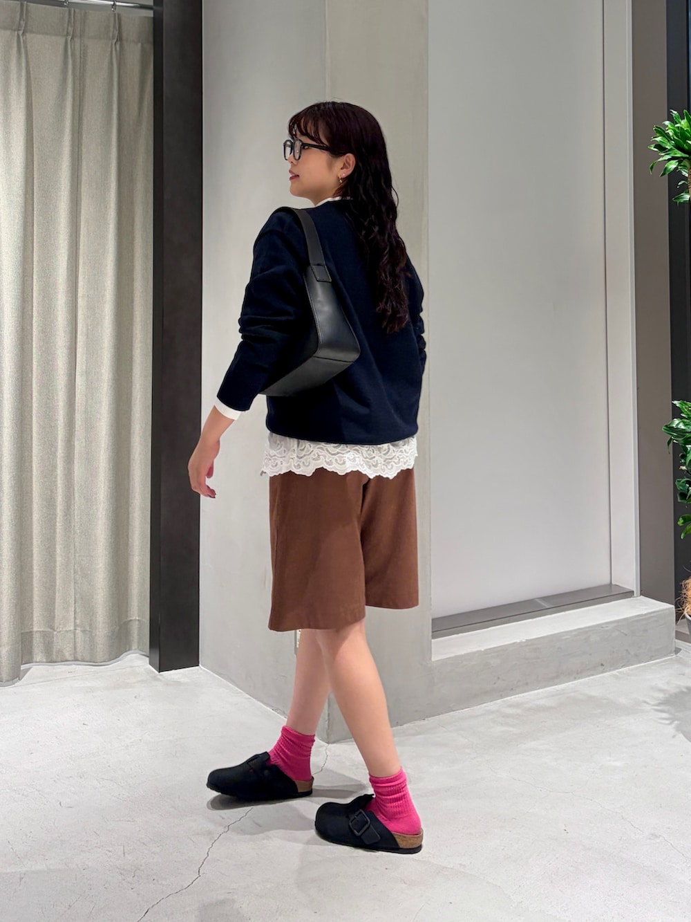 ホワイト系のシャツ/ブラウス、ブルー系のニット/セーター、ブラック系のハンドバッグを着用したレディースの秋コーディネートの3枚目の写真