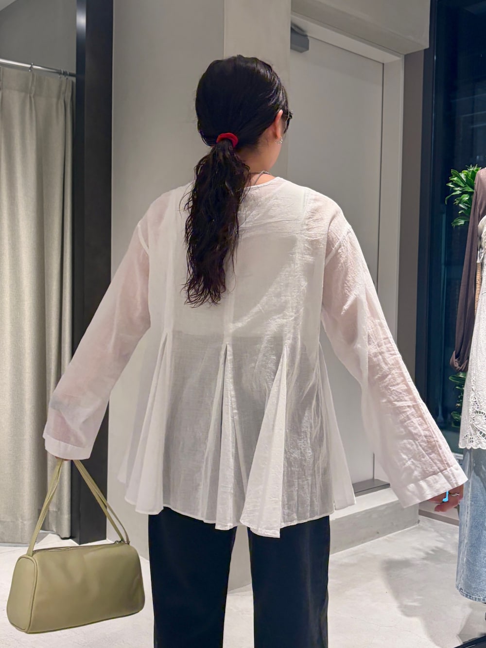 ブラック系のデニムパンツ、イエロー系のハンドバッグ、ホワイト系のシャツ/ブラウスを着用したレディースの夏コーディネートの4枚目の写真