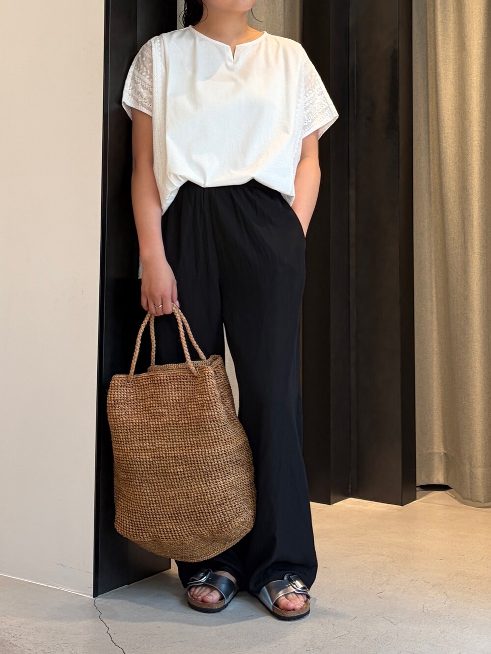 ブラック系のその他パンツ、ホワイト系のその他トップス、ブラウン系のかごバッグを着用したレディースの夏コーディネートの5枚目の写真