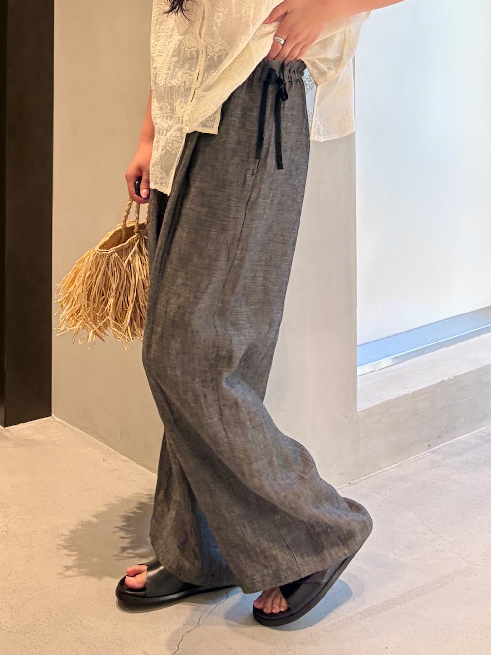 ホワイト系のシャツ/ブラウス、ブラック系のその他パンツ、ベージュ系のハンドバッグを着用したレディースの夏コーディネートの8枚目の写真
