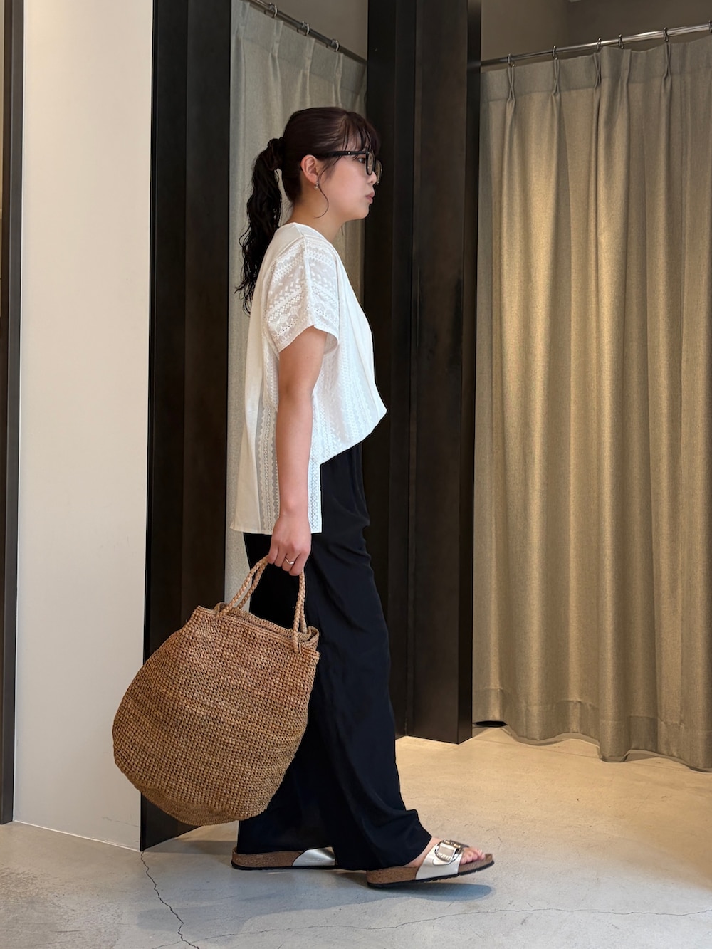 ブラック系のその他パンツ、ホワイト系のその他トップス、ブラウン系のかごバッグを着用したレディースの夏コーディネートの3枚目の写真