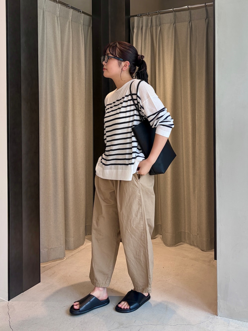 ベージュ系のその他パンツ、ブラック系のサンダル、ブラック系のトートバッグを着用したレディースの夏コーディネートの2枚目の写真