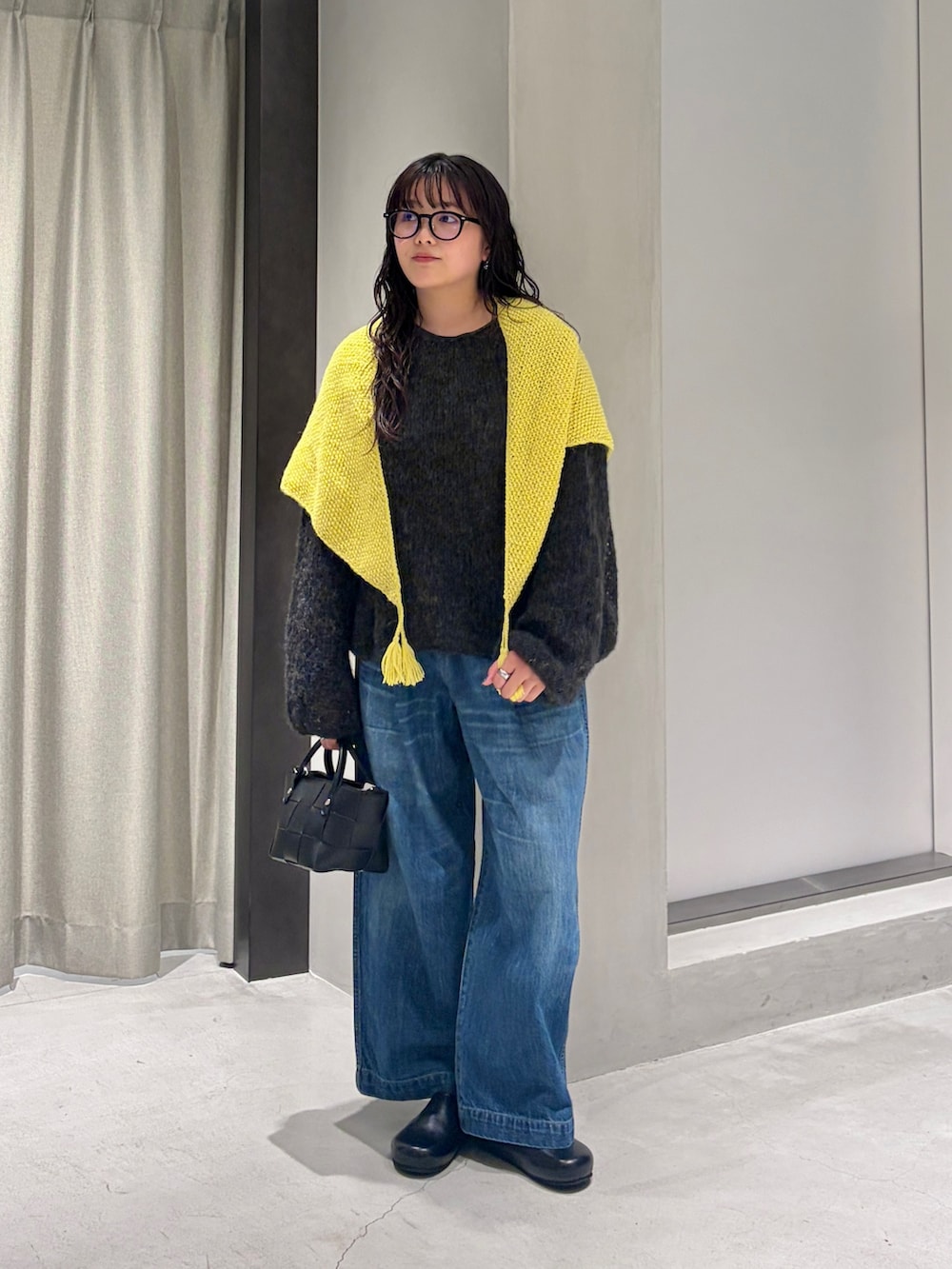グレー系のニット/セーター、ブラック系のハンドバッグ、ブラック系のその他シューズを着用したレディースの秋コーディネートの2枚目の写真