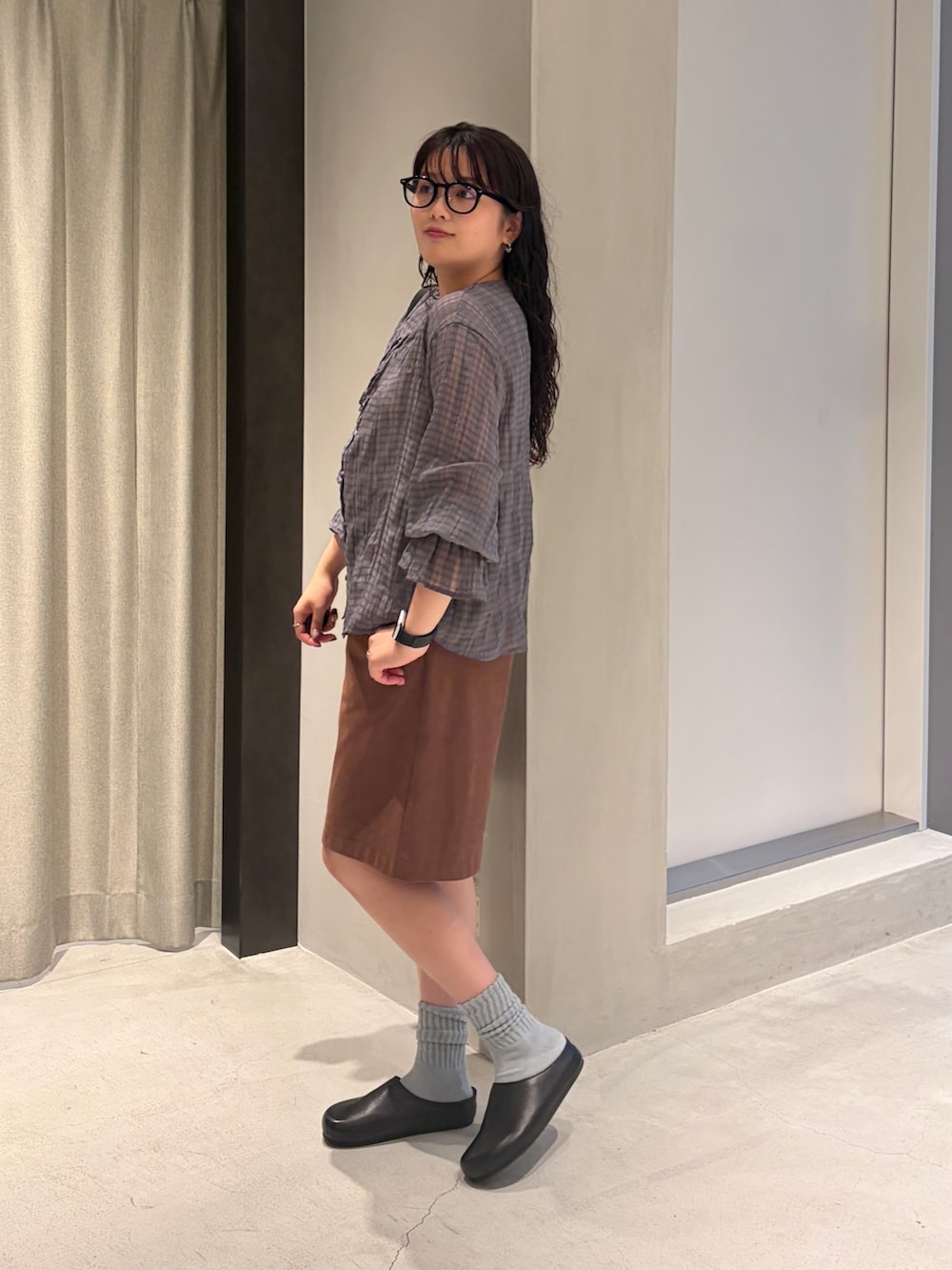 ブルー系のシャツ/ブラウス、ブラック系のハンドバッグ、ブラウン系のその他パンツを着用したレディースの夏コーディネートの2枚目の写真
