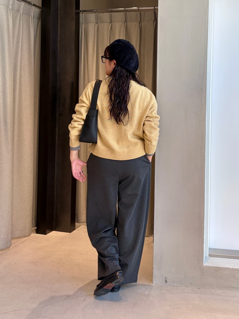グレー系のその他パンツ、イエロー系のカーディガン/ボレロ、ブラック系のハンドバッグを着用したレディースの秋コーディネートの2枚目の写真