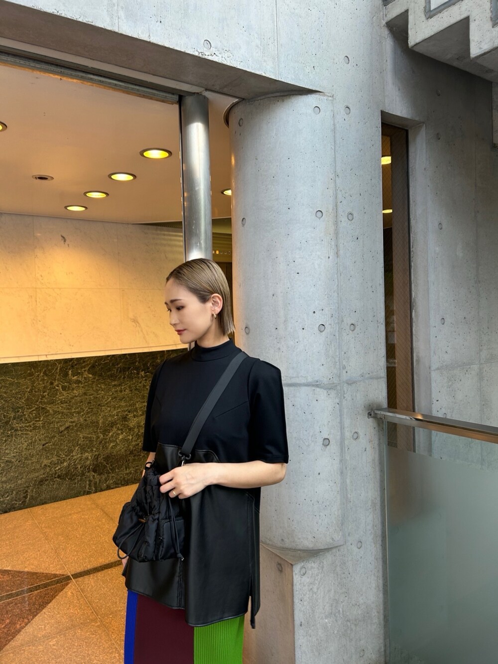 ブラウン系のスカート、ブラック系のTシャツ/カットソー、ブラック系のショルダーバッグを着用したレディースの夏コーディネートの2枚目の写真