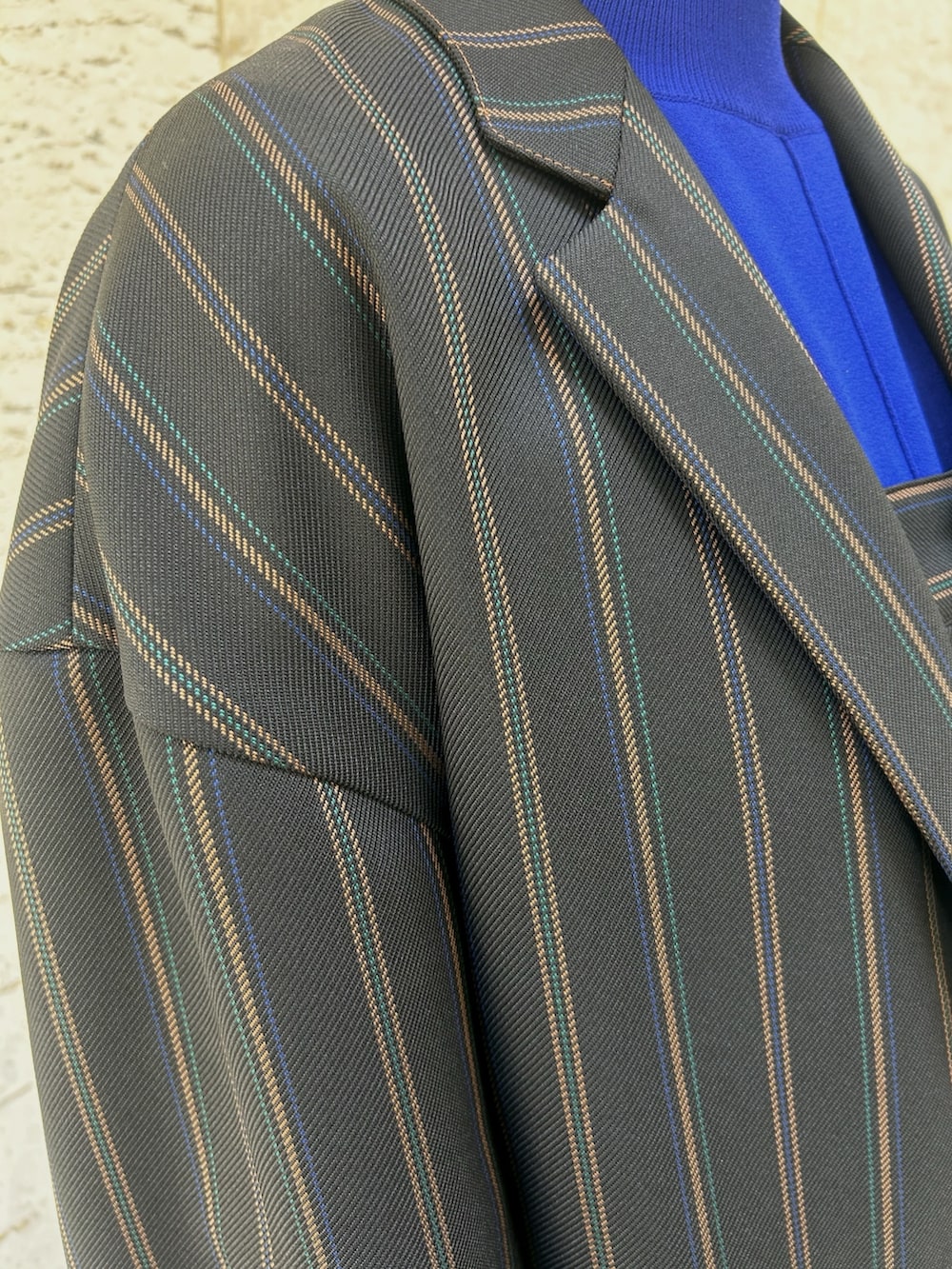 ブラック系のテーラードジャケット、ブラック系のスラックス、シルバー系のハンドバッグを着用したレディースの夏コーディネートの5枚目の写真