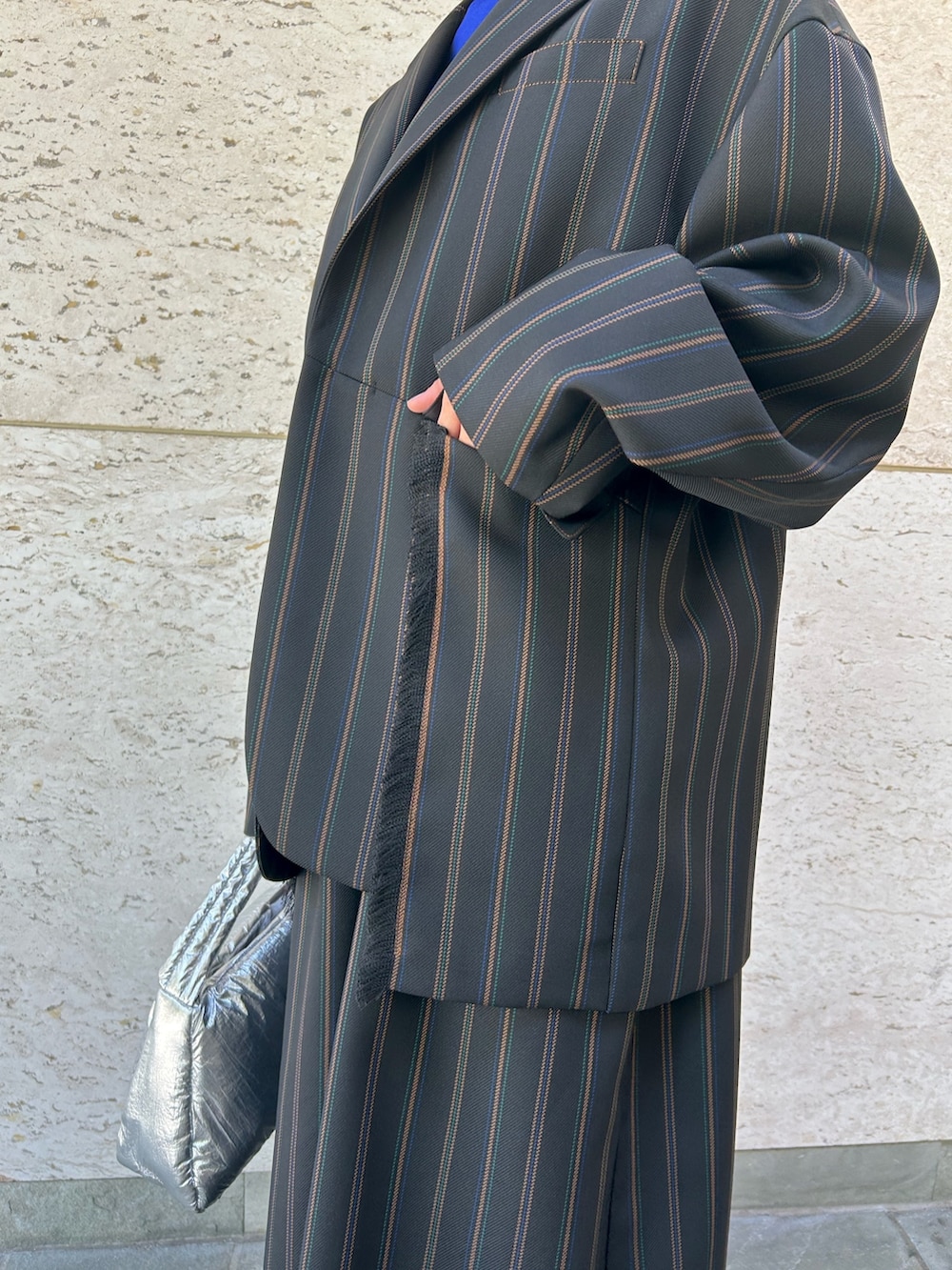 ブラック系のテーラードジャケット、ブラック系のスラックス、シルバー系のハンドバッグを着用したレディースの夏コーディネートの4枚目の写真