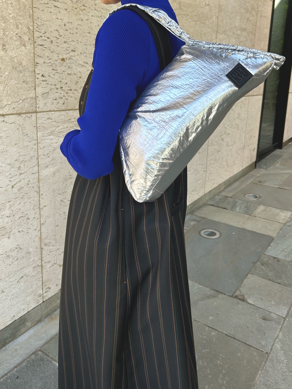 ブラック系のつなぎ/オールインワン、ブルー系のニット/セーターを着用したレディースの春コーディネートの8枚目の写真