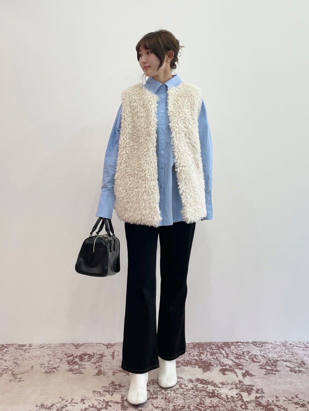 ブラック系のスニーカー、ホワイト系のベスト、ブラック系のTシャツ/カットソーを着用したレディースの夏コーディネートの3枚目の写真