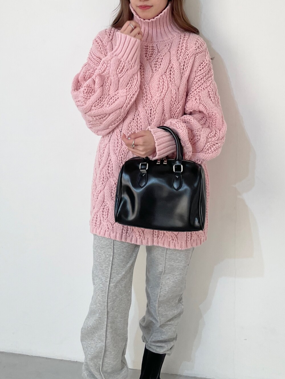 グレー系のスウェットパンツ、ピンク系のニット/セーター、ブラック系のボストンバッグを着用したレディースの冬コーディネートの2枚目の写真