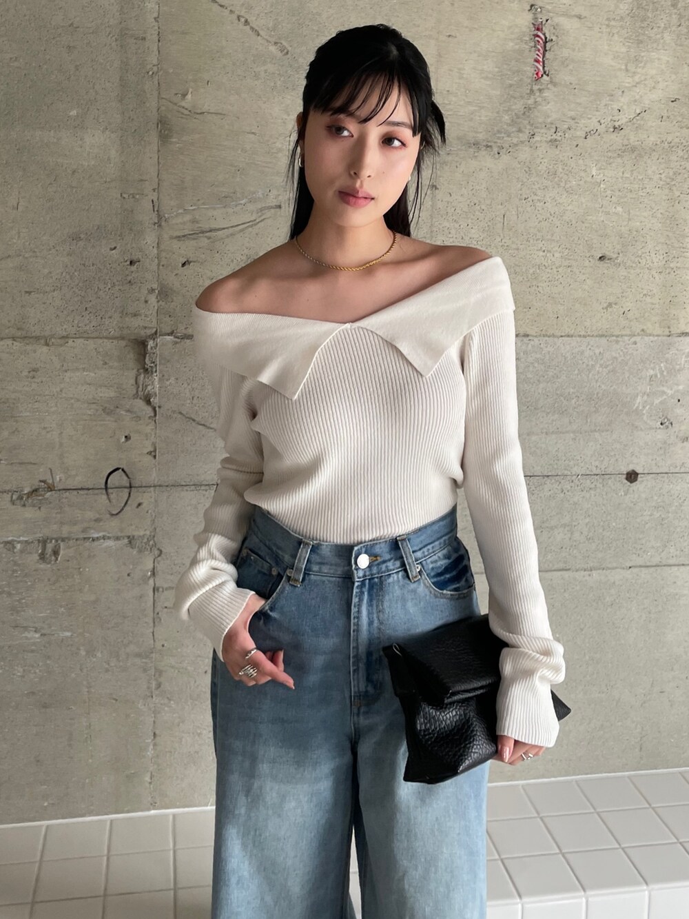 ブルー系のデニムパンツ、ベージュ系のトレンチコート、ホワイト系のニット/セーターを着用したレディースの冬コーディネートの4枚目の写真