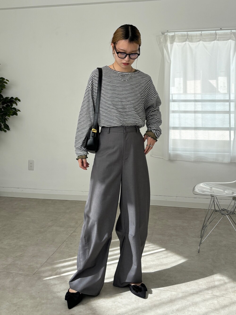 グレー系のスラックス、ホワイト系のTシャツ/カットソー、グリーン系のTシャツ/カットソーを着用したレディースの春コーディネートの2枚目の写真