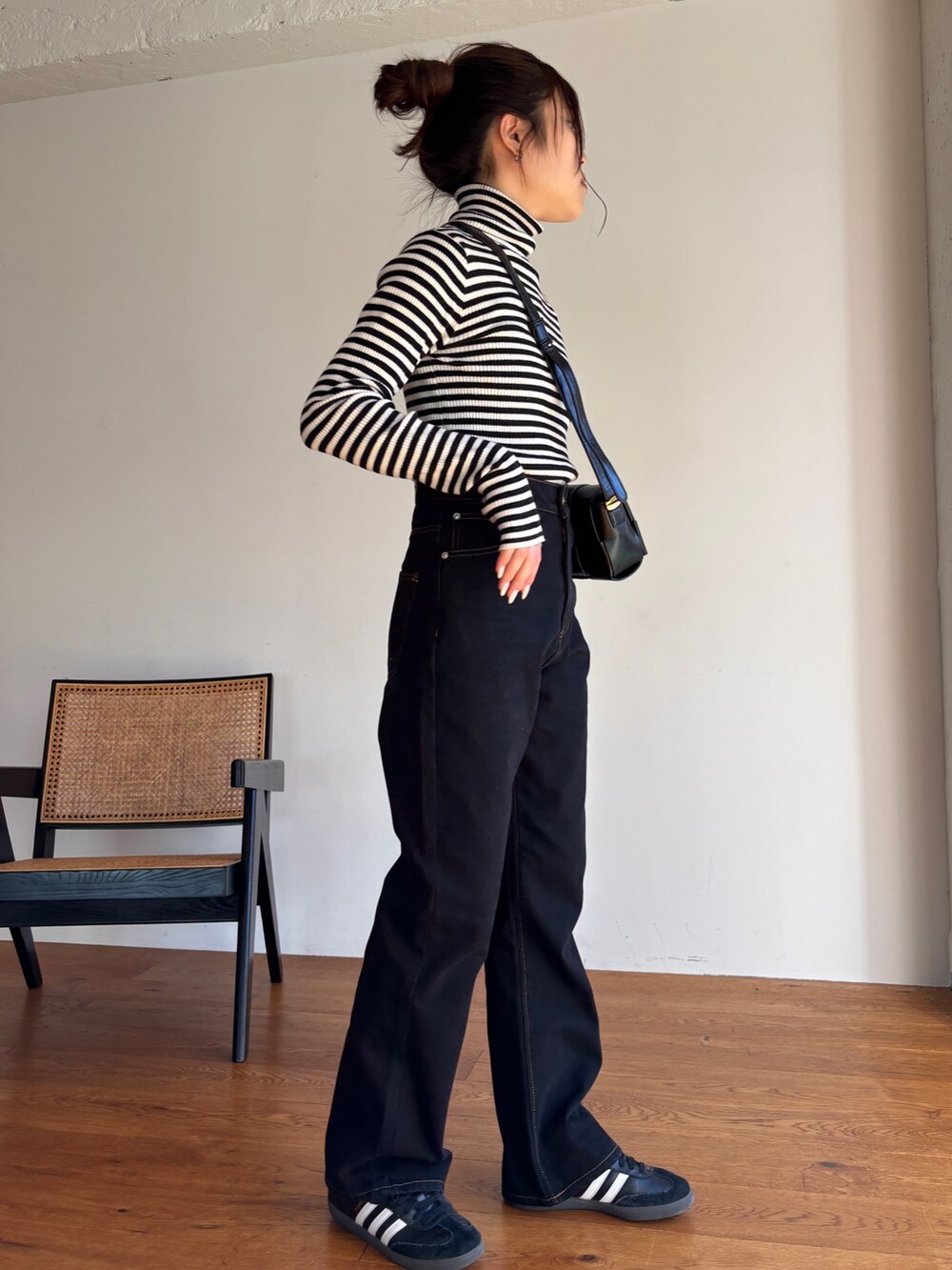 ホワイト系のニット/セーター、ブラック系のデニムパンツ、ブラック系のスニーカーを着用したレディースの冬コーディネートの4枚目の写真