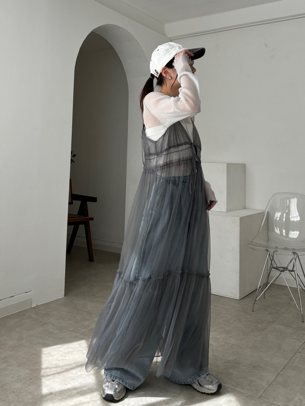 グレー系のワンピース、ホワイト系のTシャツ/カットソー、ブルー系のデニムパンツを着用したレディースの春コーディネートの4枚目の写真