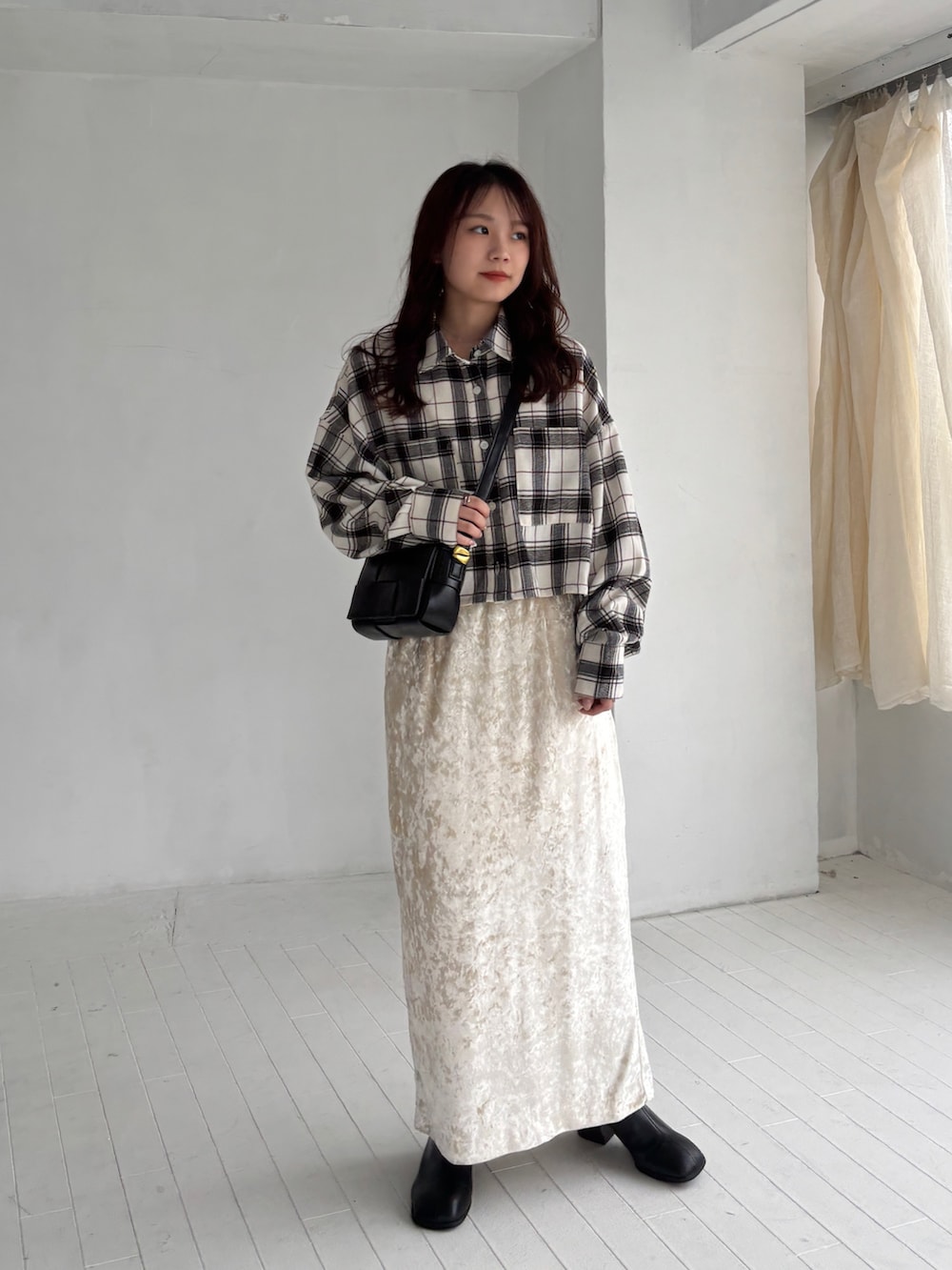 ホワイト系のシャツ/ブラウス、ベージュ系のスカート、ブラック系のブーツを着用したレディースの秋コーディネートの3枚目の写真