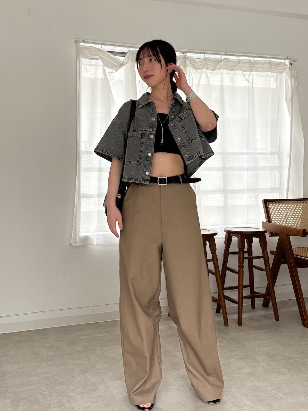 ベージュ系のスラックス、ブラック系のシャツ/ブラウス、ブラック系のチューブトップを着用したレディースの春コーディネートの2枚目の写真