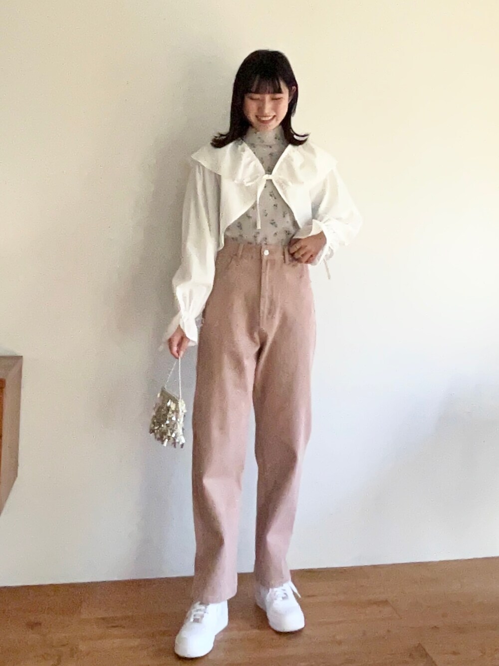 ブルー系のTシャツ/カットソー、グリーン系のスラックス、ホワイト系のスニーカーを着用したレディースの冬コーディネートの5枚目の写真
