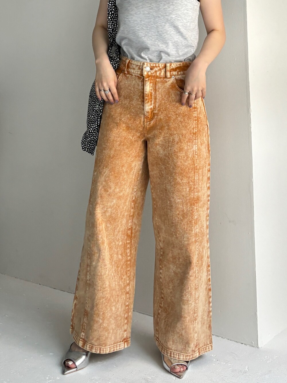 オレンジ系のデニムパンツ、ベージュ系のタンクトップ、シルバー系のサンダルを着用したレディースの夏コーディネートの4枚目の写真