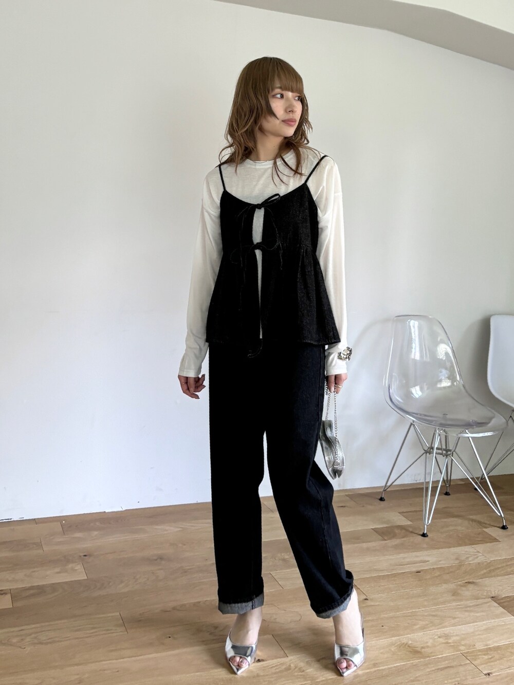 ブラック系のキャミソール、ホワイト系のTシャツ/カットソー、ブラック系のデニムパンツを着用したレディースの春コーディネートの2枚目の写真