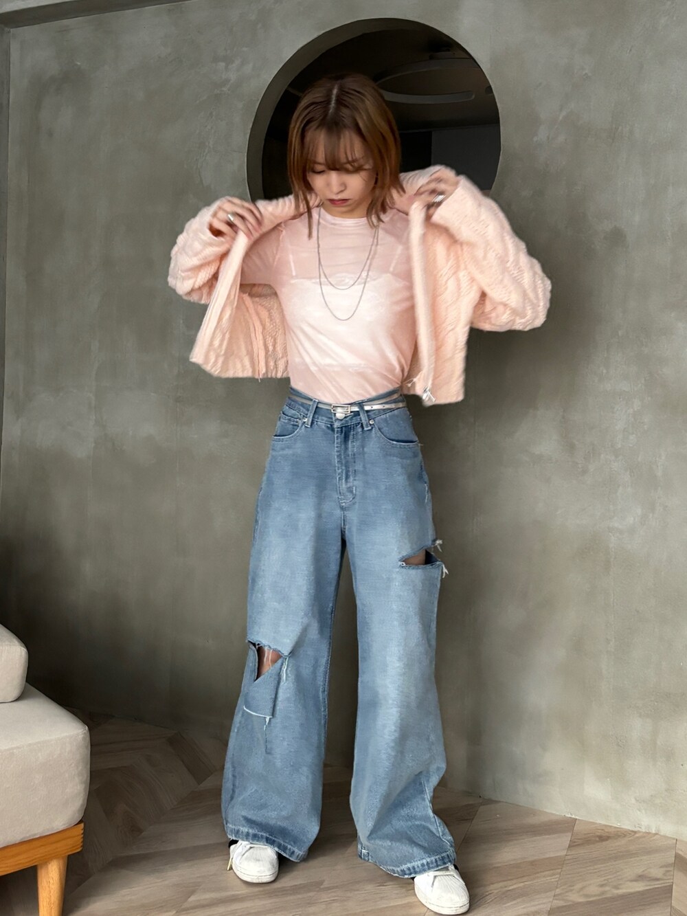 ピンク系のカーディガン/ボレロ、ピンク系のTシャツ/カットソー、ブルー系のデニムパンツを着用したレディースの冬コーディネートの2枚目の写真