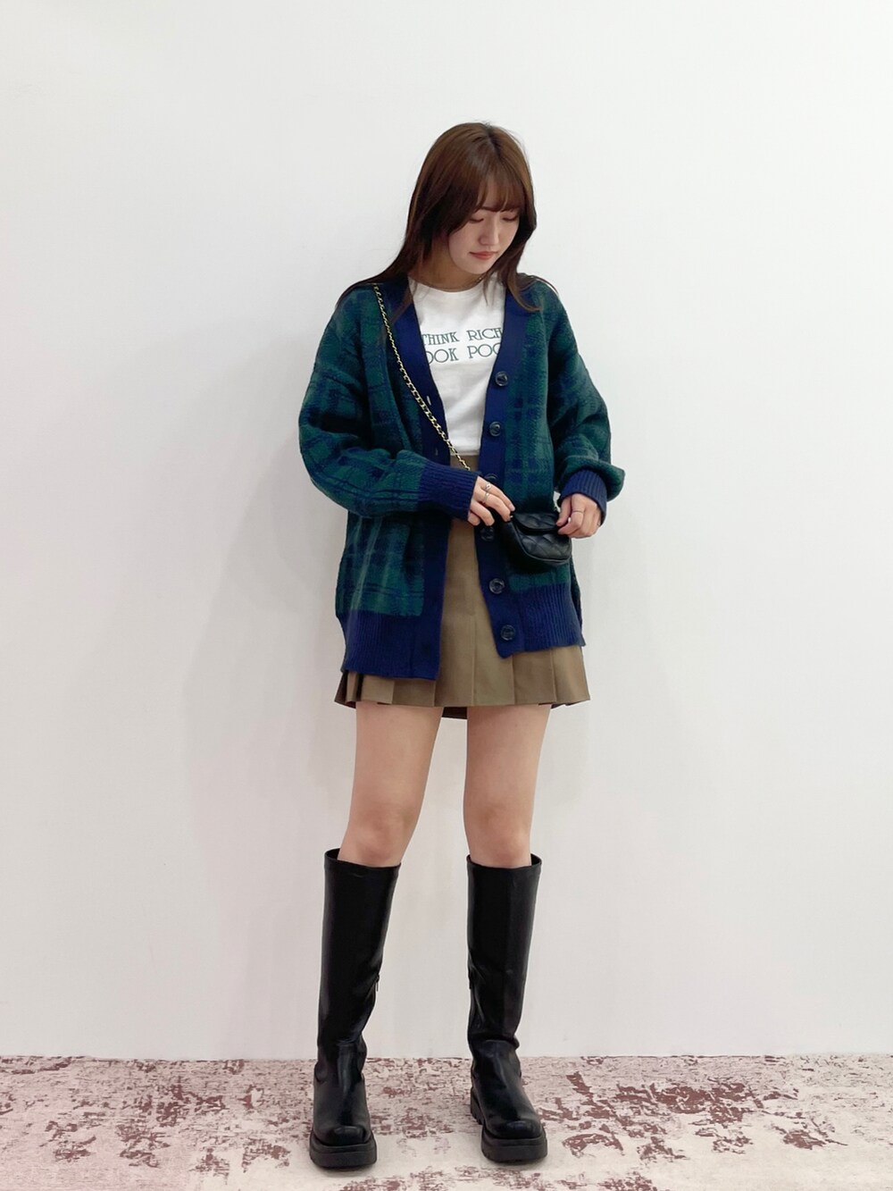 ブラック系のボストンバッグ、ベージュ系のブーツ、ブルー系のカーディガン/ボレロを着用したレディースの秋コーディネートの3枚目の写真