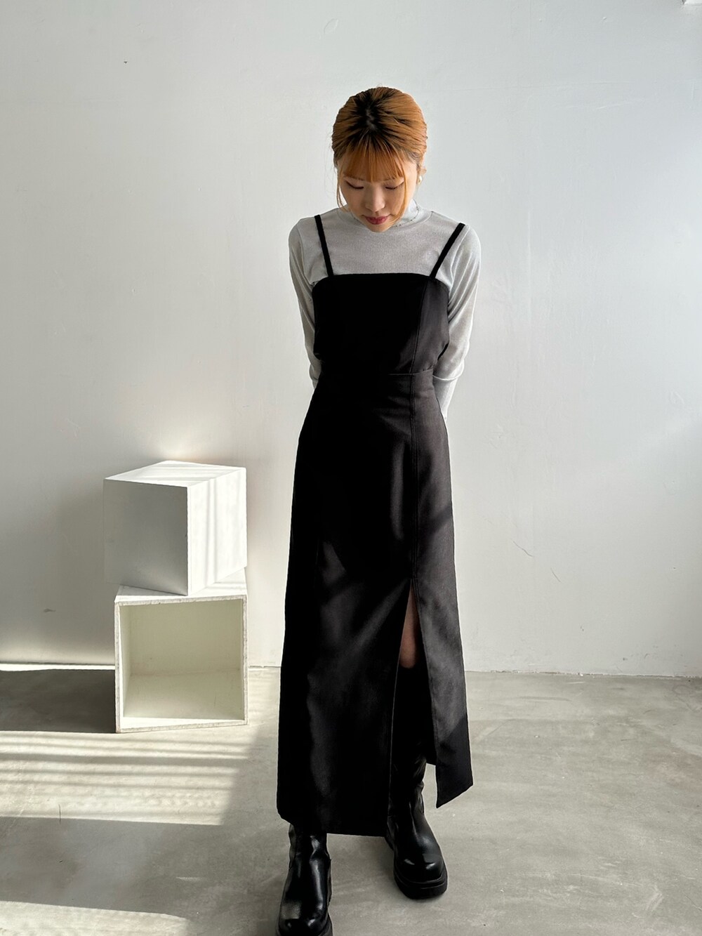 ブラック系のワンピース、ホワイト系のTシャツ/カットソー、ブラック系のブーツを着用したレディースの冬コーディネートの5枚目の写真