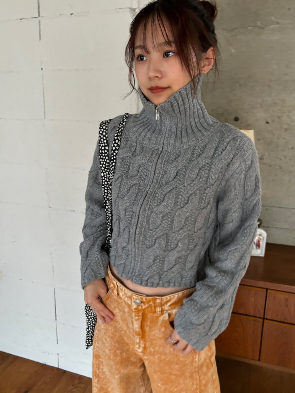 ホワイト系のニット/セーター、オレンジ系のデニムパンツ、ホワイト系のスニーカーを着用したレディースの秋コーディネートの3枚目の写真