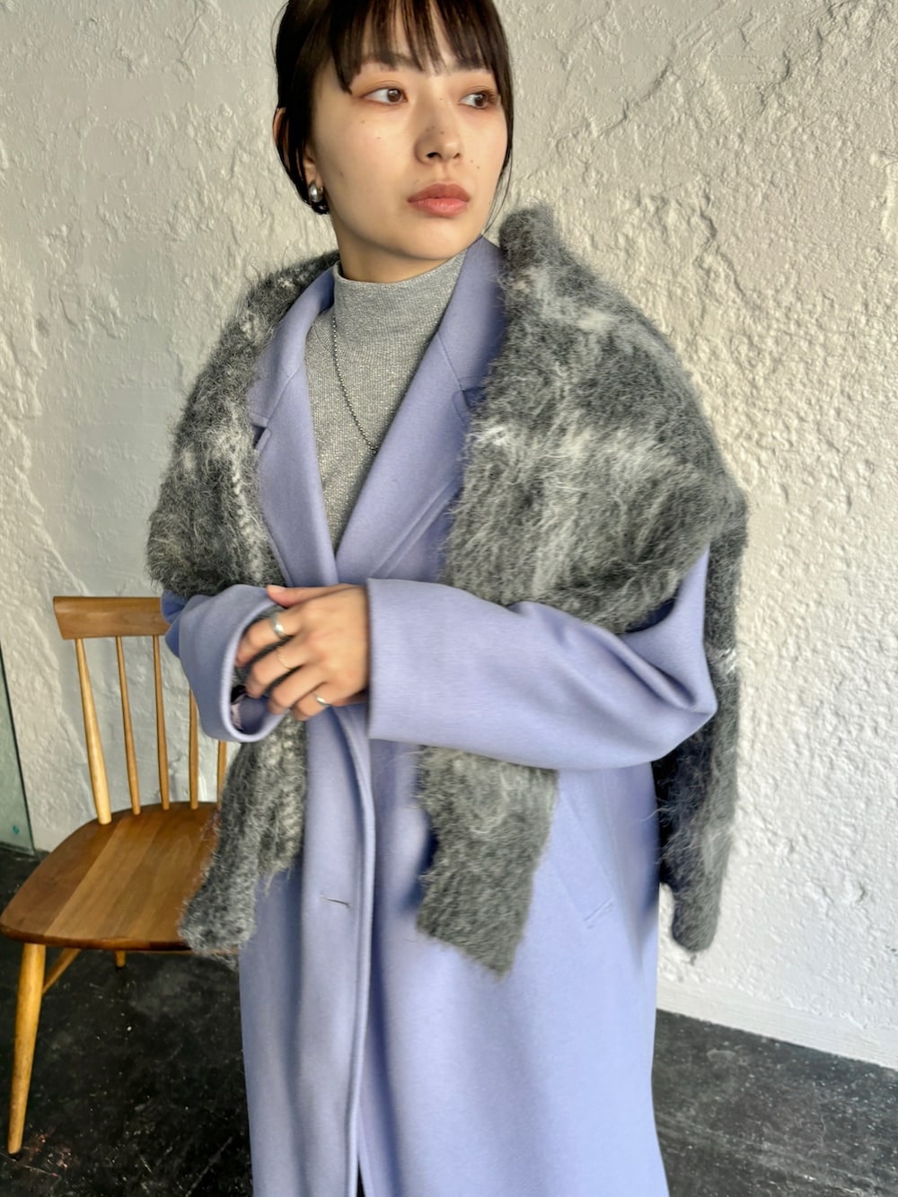 ブルー系のチェスターコート、ブラック系のカーディガン/ボレロ、グレー系のスラックスを着用したレディースの冬コーディネートの4枚目の写真