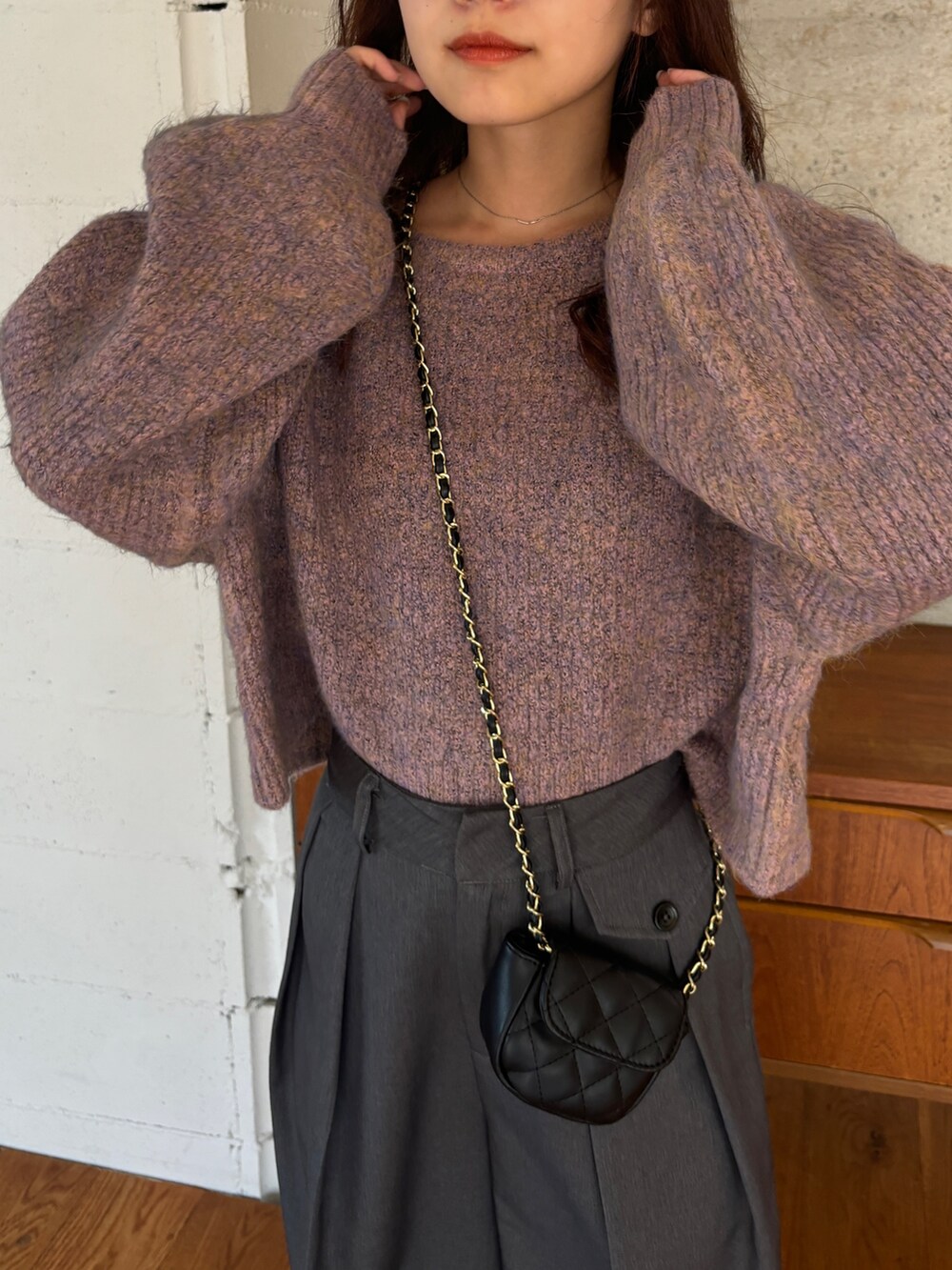 ピンク系のニット/セーター、グレー系のスラックス、ブラック系のブーツを着用したレディースの秋コーディネートの3枚目の写真