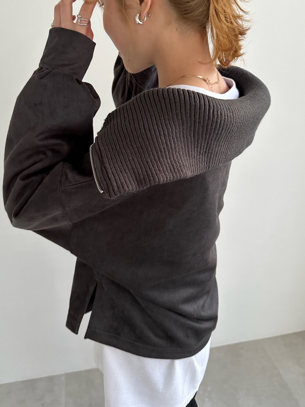 グレー系のTシャツ/カットソー、ブラック系のスラックス、シルバー系のバレエシューズを着用したレディースの冬コーディネートの3枚目の写真