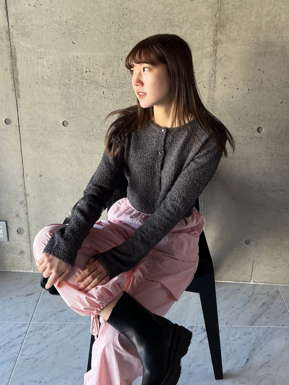 グレー系のカーディガン/ボレロ、ピンク系のカーゴパンツ、ブラック系のブーツを着用したレディースの春コーディネートの4枚目の写真