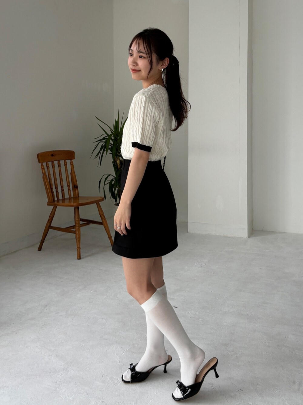 ブラック系のスカート、ホワイト系のニット/セーター、その他のその他を着用したレディースの夏コーディネートの2枚目の写真