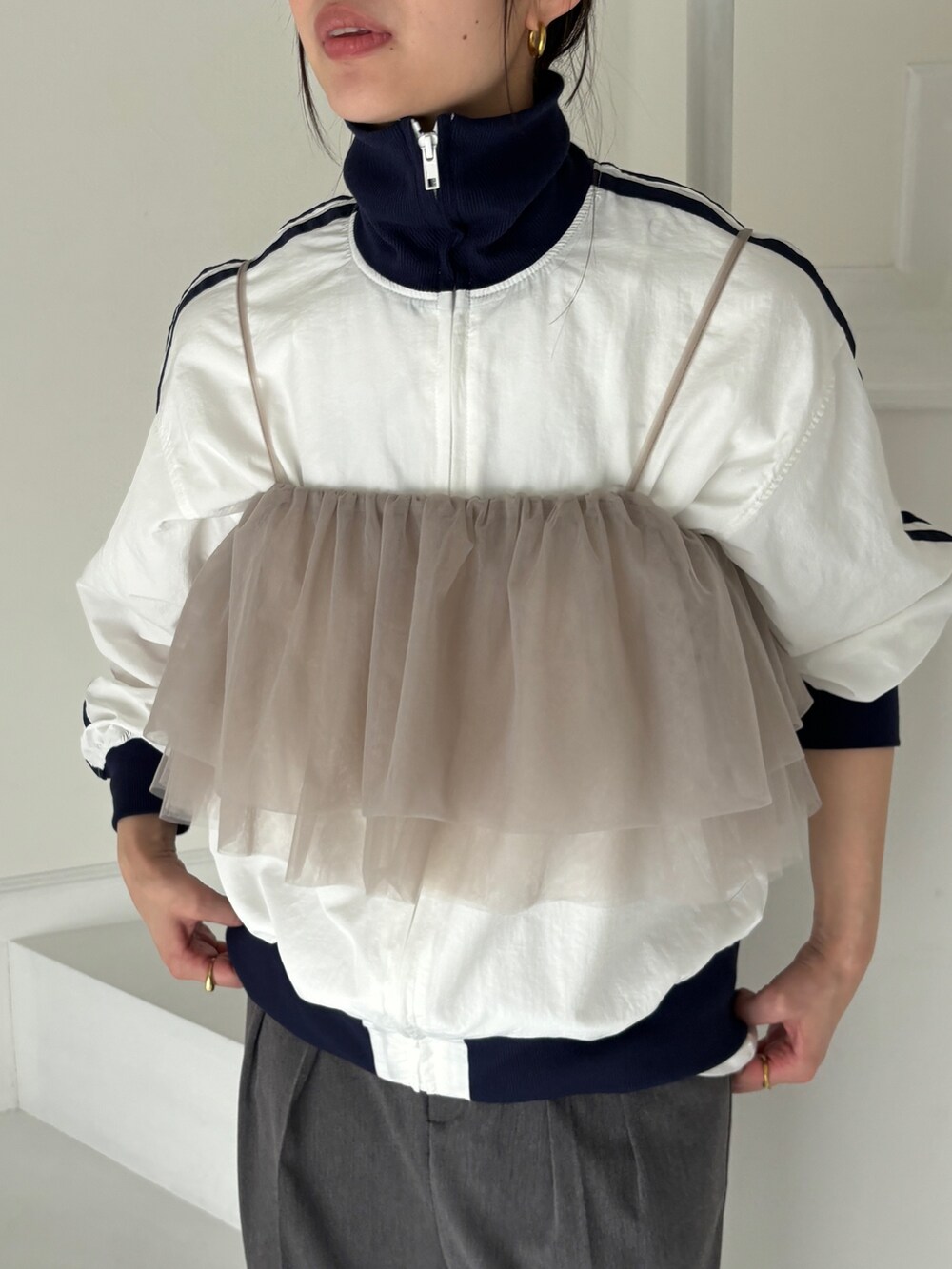 グレー系のトレンチコート、ホワイト系のその他アウター、グレー系のスラックスを着用したレディースの冬コーディネートの6枚目の写真