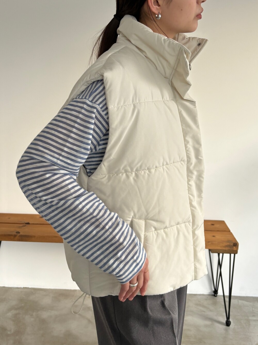 ホワイト系のベスト、グレー系のスラックス、その他のその他を着用したレディースの冬コーディネートの3枚目の写真