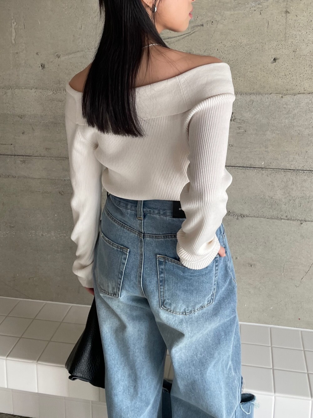 ブルー系のデニムパンツ、ベージュ系のトレンチコート、ホワイト系のニット/セーターを着用したレディースの冬コーディネートの5枚目の写真