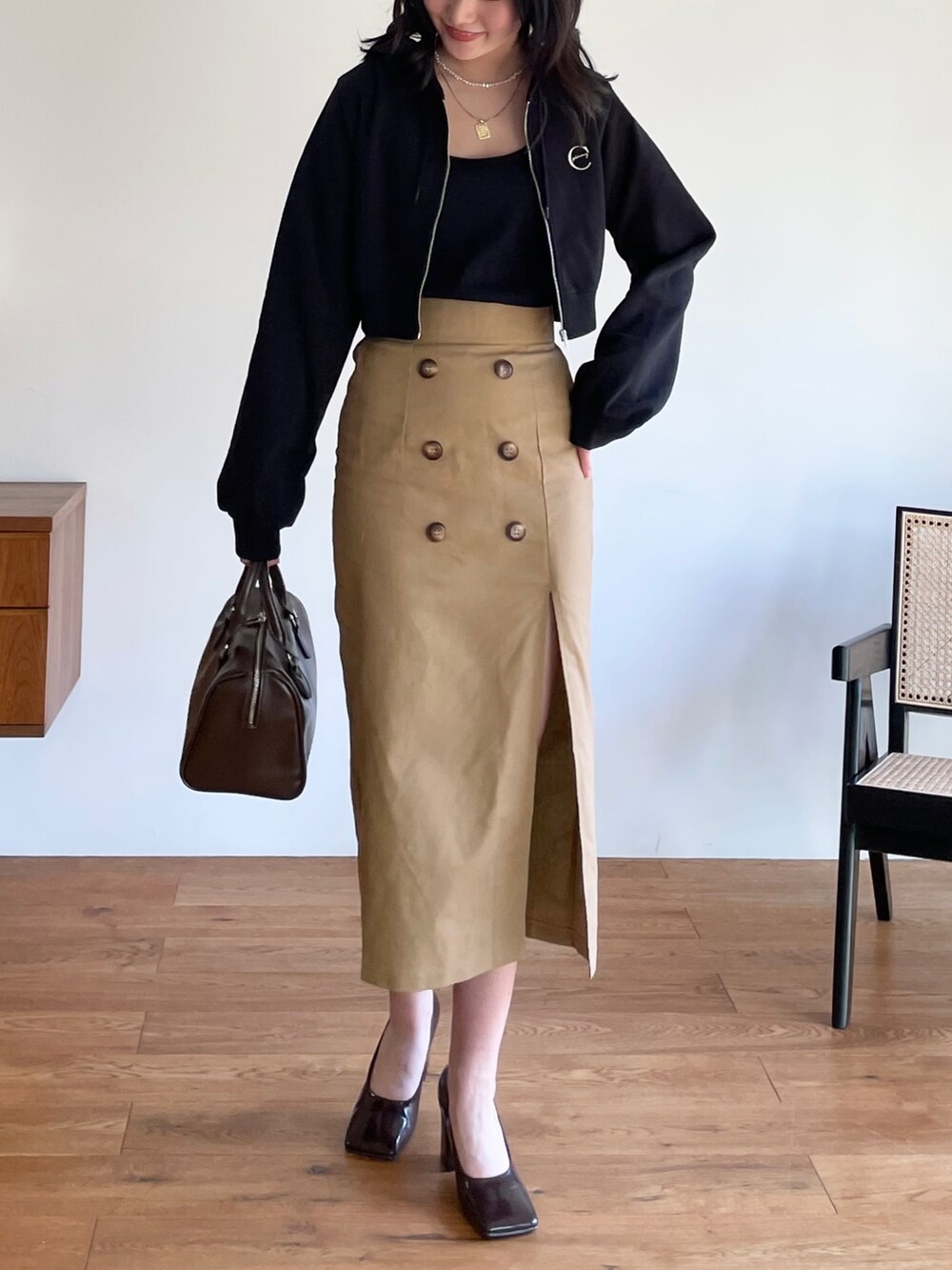 シルバー系のバレエシューズ、ブラック系のボストンバッグ、ブラック系のスカートを着用したレディースの冬コーディネートの2枚目の写真