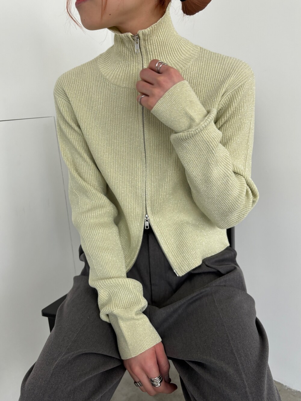 グレー系のスラックス、ブラック系のスニーカー、ベージュ系のニット/セーターを着用したレディースの冬コーディネートの4枚目の写真